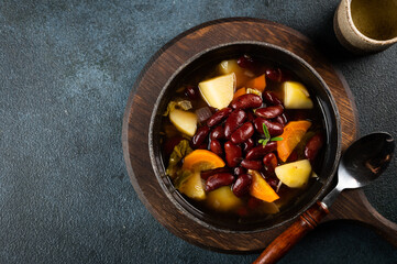 Homemade bean soup with ingredients. horizontal view from above. Ribolita. Vegetarian soup. Bean stew. Eintopf soup. Beans ragout.
