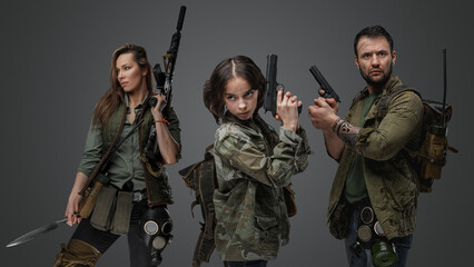Studio shot of isolated on gray background three post apocalyptic survivors.
