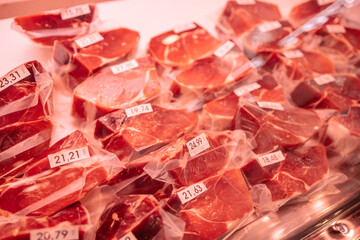 Vacuum-packed meat at La Boqueria market in Barcelona, ​​Spain. Famous Iberico meat products produced from black Iberian pigs 