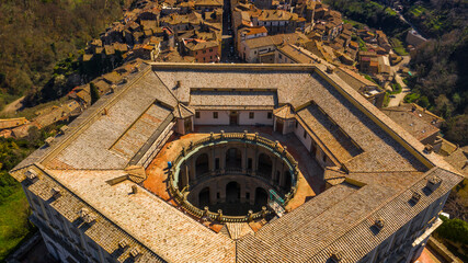 Aerial view of the Villa Farnese, a pentagonal mansion in Caprarola, near Viterbo, Italy. It is a massive Renaissance and Mannerist construction. It is built on a five-sided plan in reddish gold stone - obrazy, fototapety, plakaty