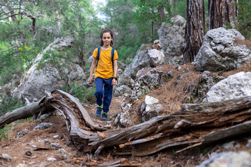 Adventure and travel. a little boy with a backpack is walking along a forest path. hiking with children.