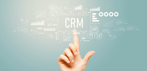 Obraz na płótnie Canvas CRM - Customer Relationship Management theme with hand pressing a button on a technology screen