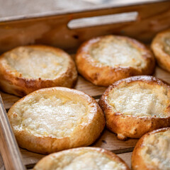 Vatrushky with cottage cheese in wooden tray. Fresh homemade pastries for tea. Eastern European pastry. Yeast dough. Close-up. Top view. Soft focus.