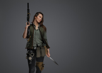 Shot of Killer woman dressed in uniform looking to side against gray background.