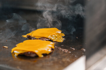 professional kitchen in hotel restaurant close up smash burger with grilled cheese food concept - obrazy, fototapety, plakaty