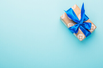 Fototapeta na wymiar Gift box with a satin bow on a blue background.
