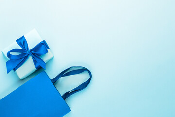 Blue gift box with blue ribbon and bow and blue craft bag.Greeting card.