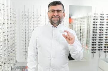 Doctor holds in his hand container with soft contact lenses for single use. Ophthalmologist prescribes use of one-day contact lenses for vision correction. Myopia and eyesight problem concept.