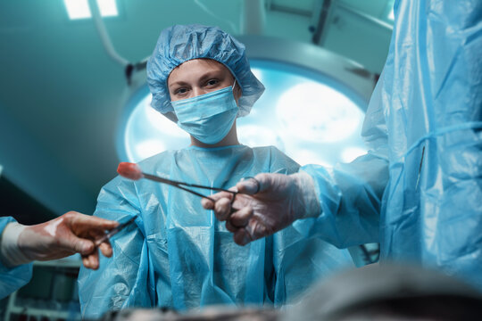 Shot of professional doctor woman looking at camera during operation.