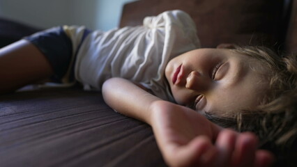 One child asleep during afternoon nap on couch. adorable little boy napping and resting. Relaxed kid with eyes closed