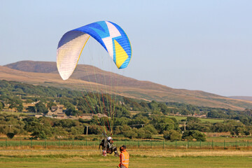 Paramotor pilot taking off in the hills of Wales	