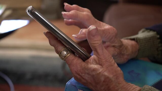 An elderly woman's hands while using a smart phone