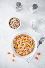Corn red bell pepper black and white and brown rice in a bowl