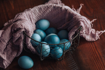 blue easter eggs in basket on a wooden table