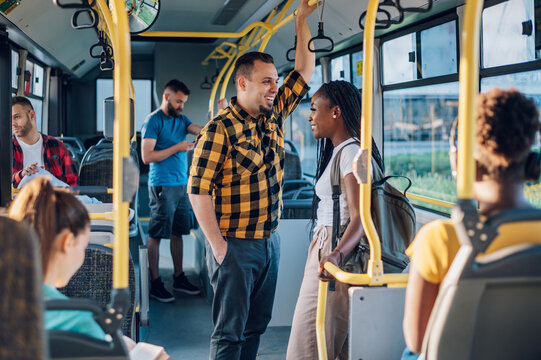 Multiracial friends talking while riding a bus in the city - Powered by Adobe