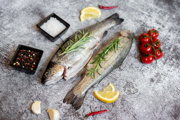 raw trout with spices on stone background