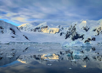 Fototapeta na wymiar Impressive glacier and beautiful reflection on water in Antarctica, scenic landscape in Antarctic Peninsula