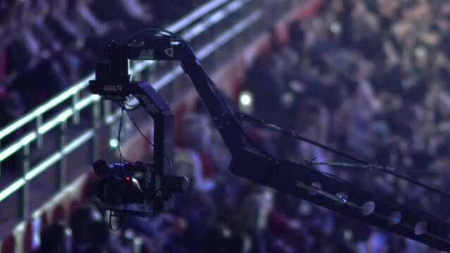Professional digital video camera on a crane over people heads record a business meeting event, selective focus