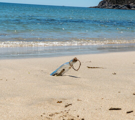 Fototapeta na wymiar A glass bottle with a message inside found on a beach
