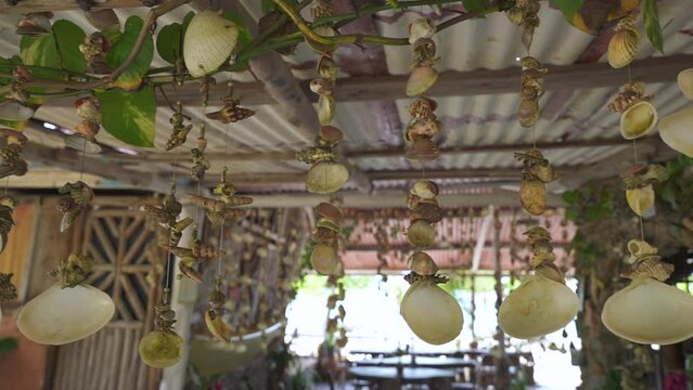 Sea shells decorations hang on the ceiling in the caribbean restaurant on the beach