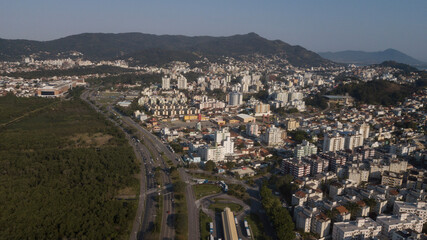 Naklejka premium Paisagem Urbana Cidade Florianopolis Centro Trindade Itacorubi Beira Ilha Mar Baía Norte Morro da Cruz Prédios Arquitetura Engenharia Urbanismo Santa Catarina Por do Sol Drone Aérea 