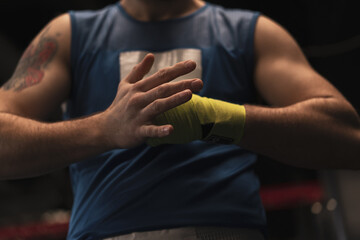 Male boxer wraps his arms before a fight Young sportsman prepares for a fight close-up Sports concept