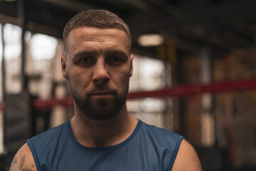 Fototapeta premium Close up of sporty sweaty boxer with serious face in gym