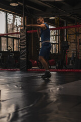 Fototapeta premium A boxer in the gym who fights with the shadow practices punches