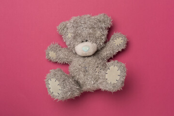Cute teddy bear on color background, top view