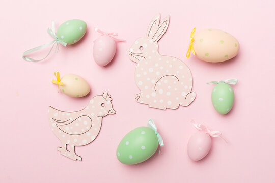 Cute easter bunny and eggs on color background, top view