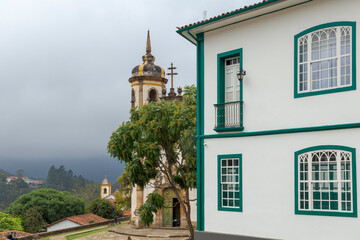 Fototapeta na wymiar Vista de casarão colonial e torre da Igreja São Francisco de Assis, em Ouro Preto, Minas Gerais.