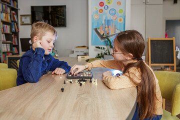 Children play game of checkers. Concept of education, hobby and leisure.