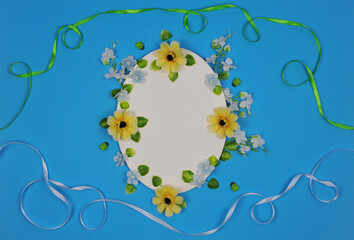 Bright blue greeting floral  background with white oval frame mockup, decorated  with white and yellow   flowers, ladybugs and wavy ribbons . Birthday Mothers day concept. Free copy space