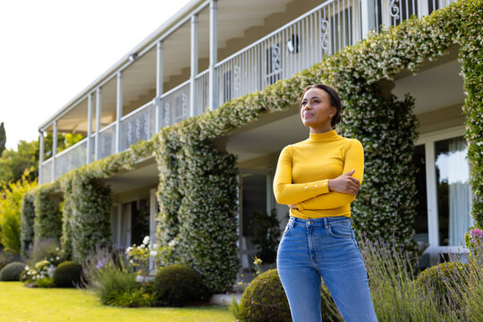 Portrait of happy biracial woman looking at camera in garden - Powered by Adobe