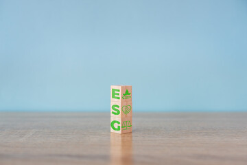 Wooden cubes with abbreviation  ESG icons on blue background. ESG concept of environmental, social...