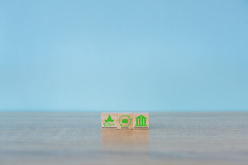 Obraz premium Wooden cubes with abbreviation ESG icons on blue background. ESG concept of environmental, social and governance. Sustainable corporation development. Copy space.