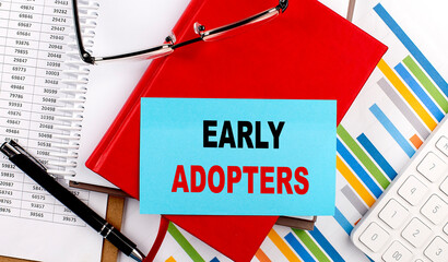 EARLY ADOPTERS text on sticky on red notebook on chart background