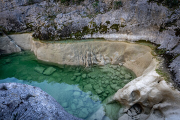 piscine naturelle verte au fond d'un ravin créée par la sécheresse