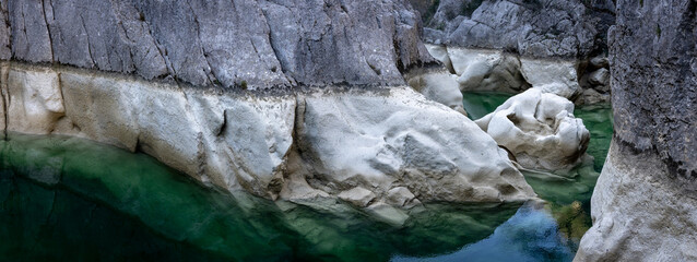 Une rivière verte au fond d'un canyon, avec les niveaux de sécheresse sur les paroies