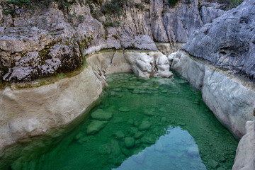 une piscine naturelle, avec de l'eau verte créée par la sécheresse au fond d'un canyon