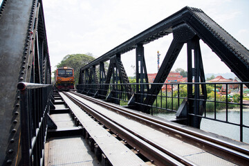 Fototapeta na wymiar Passenger train pass through the River Kwai Bridge or Death railway bridge in Kanchanaburi, Thailand
