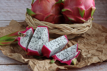Healthy dragon fruits basket weave on wooden background