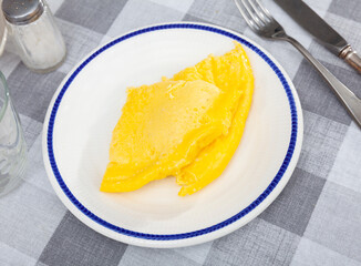 Thin omelette served with bread for breakfast closeup