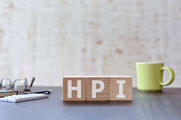 There is wood cube with the word HPI. It is an acronym for Human, Performance, Improvement an...