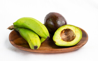 banana and avocado on a wooden plate