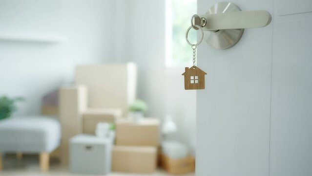 Moving house, relocation. The key was inserted into the door of the new house, inside the room was a cardboard box containing personal belongings and furniture. move in the apartment or condominium