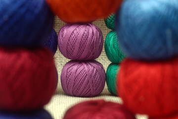 multi-colored skeins of threads stacked one on top of the other, skeins of threads close-up