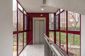 An elevator in a retrofit residential building with an external metal and glass structure