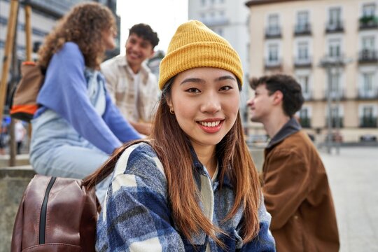 Joyful Chinese girl with friends in Madrid.