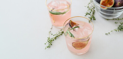 Glasses of tasty fig lemonade on light background with space for text